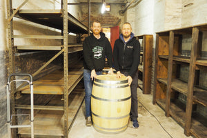 Ruhrpott Whisky - Die Gründer Andree und Björn hinter einem Fass aus deutscher Eiche. Im Hintergrund ist der Eingang zum Lagerraum in der alten Kaue der Maschinenhalle der Zeche Schlägel & Eisen. Ruhrpott Whisky produziert deutschen Whisky in Herten (NRW)